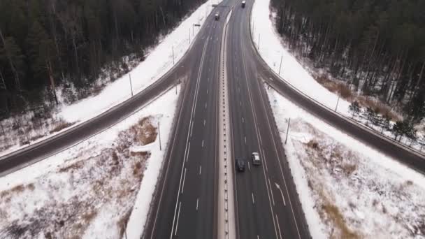 Voorstedelijke, lange snelweg met snelrijdende vrachtwagens en auto 's in de winter, luchtfoto. — Stockvideo