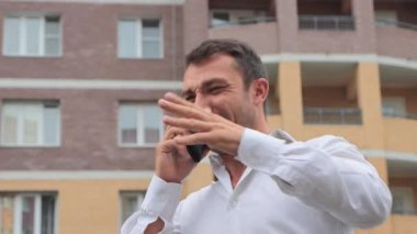 Zevk ve neşe dolu bir iş adamının yakın çekimi telefonda konuşuyor.. 