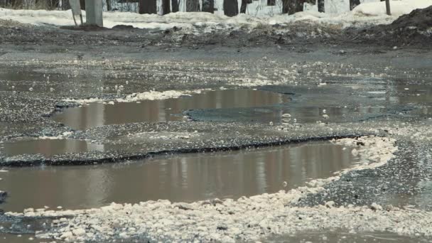Diepe kuilen met water bij slecht weer, zwaar beschadigde wegeninfrastructuur. — Stockvideo