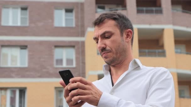 Gros plan d'un homme d'affaires travaillant intensément dans un smartphone. — Video
