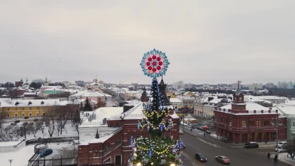 Año Nuevo copo de nieve en la parte superior del árbol de la ciudad contra el cielo. — Vídeos de Stock