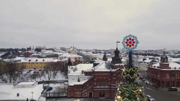 街の背景を背景にクリスマスツリーの上に雪の結晶. — ストック動画
