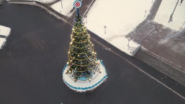 Märchenhafter, schlanker Weihnachtsbaum auf dem Stadtplatz, Luftaufnahme. — Stockvideo