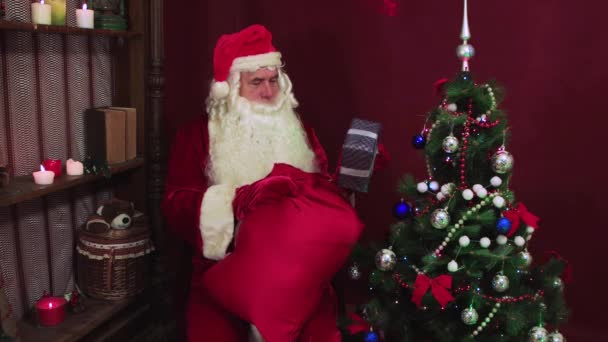 Père Noël moderne prend des cadeaux d'un sac rouge — Video