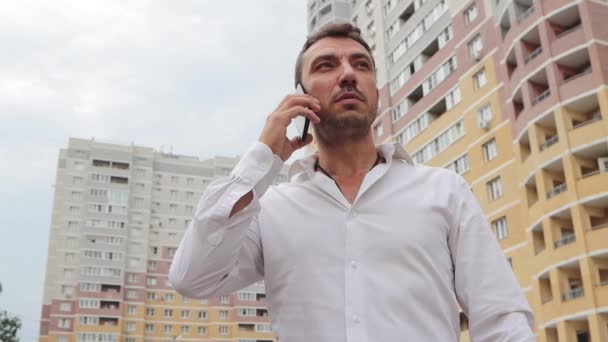 Un jeune homme d'affaires parle au téléphone sérieusement et émotionnellement. — Video