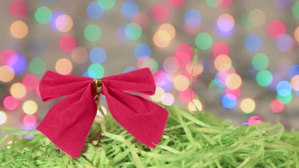 Rode kerstboog op groen tinsel, Nieuwjaar achtergrond. — Stockvideo