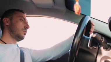 Yakışıklı bir adam direksiyonu çeviriyor..