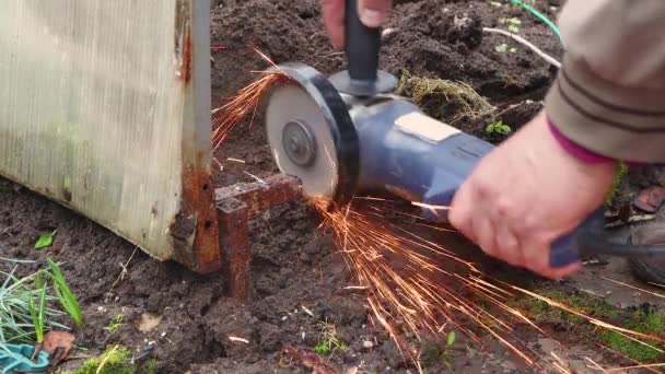 Les mains masculines coupent des métaux rouillés avec une meuleuse d'angle. — Video
