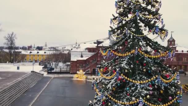 Schöne leuchtende Girlanden und eine Schneeflocke auf der Spitze des städtischen Neujahrsbaums — Stockvideo