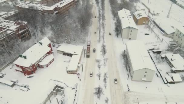 車は街の道路に沿って運転し、豊富な雪で覆われ、吹雪の後。. — ストック動画