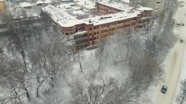 Uma casa velha com um telhado destruído coberto com neve depois de uma nevasca. — Vídeo de Stock