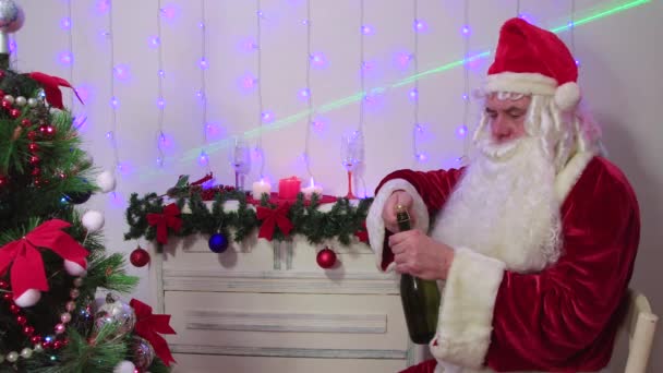 Santa Claus otevírá šampaňské, blahopřeje při pohledu do kamery. — Stock video