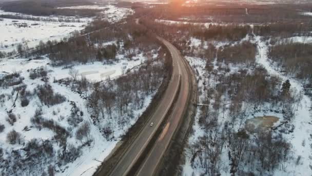 Perfect winterlandschap met een weg bij zonsondergang, uitzicht vanuit de lucht. — Stockvideo