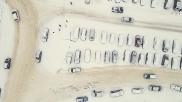 Машины покрыты снегом после метели и проезжают по дороге. — стоковое видео