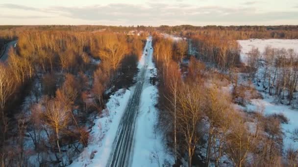 Gün batımında kır yolu olan karlı kış manzarası, hava manzarası. — Stok video