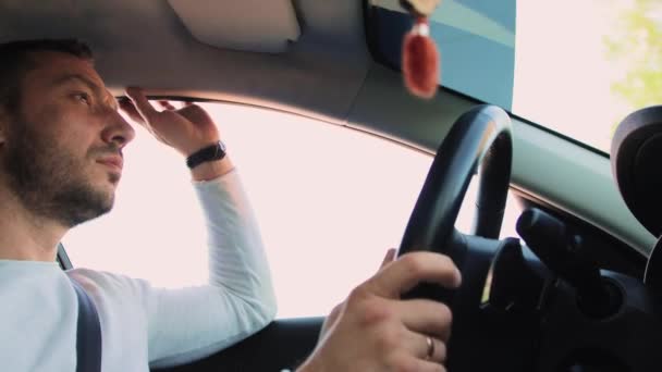 Ένας όμορφος άντρας οδηγάει, ακουμπώντας το χέρι του στο παράθυρο.. — Αρχείο Βίντεο