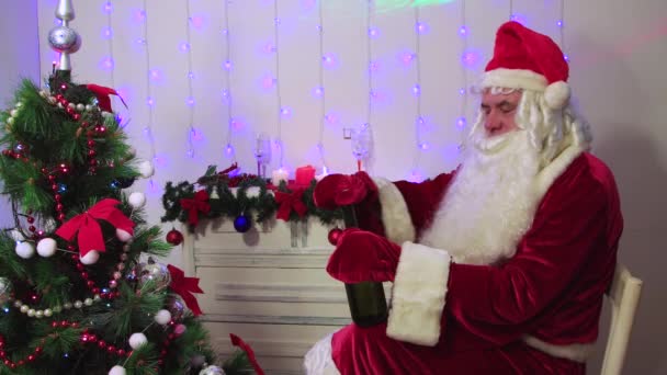 Święty Mikołaj w rękawiczkach nie może otworzyć butelki szampana.. — Wideo stockowe