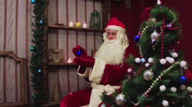 Modern Noel Baba mavi bir top tutuyor ve ona hayran.. 