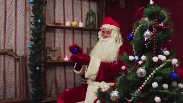 Modern Santa Claus holds a blue ball and admires it. — Stock Video