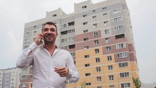 Empresário feliz emocionalmente com um sorriso fala ao telefone. — Vídeo de Stock