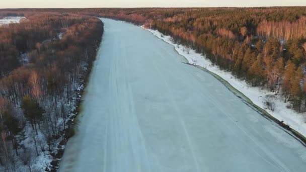 Ovanligt vinterlandskap med frusen flod vid solnedgången, flygutsikt. — Stockvideo