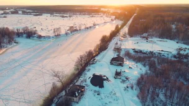 Un majestuoso paisaje invernal con un río congelado al atardecer, vista aérea. — Vídeos de Stock