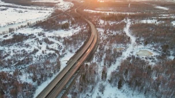Ovanligt vinterlandskap med motorväg vid solnedgången, flygutsikt. — Stockvideo