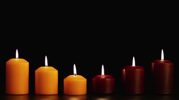 Six bougies magnifiquement brûlantes sur fond noir dans l'obscurité. Espace de copie. — Video