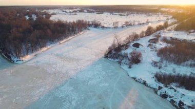 Gün batımında donmuş nehirle sakin kış manzarası, hava manzarası.