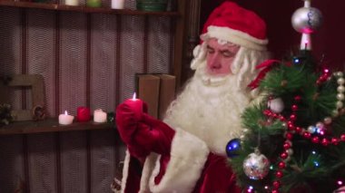 Modern Noel Baba elinde yanan bir mum tutuyor ve tebrik ediyor..
