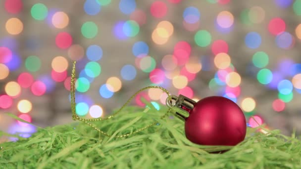Červený vánoční míč na zeleném tinsel, Vánoční pozadí, kopírovací prostor. — Stock video
