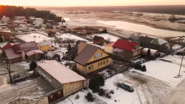 Околиці села під снігом в помаранчевому світлі сонця . — стокове відео
