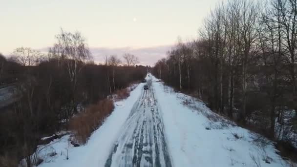 Piękny śnieżny zimowy krajobraz z drogą w lesie o zachodzie słońca, — Wideo stockowe