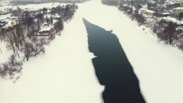 Piękny zimowy krajobraz z zamarzniętą rzeką i przedmieściami, widok z powietrza. — Wideo stockowe