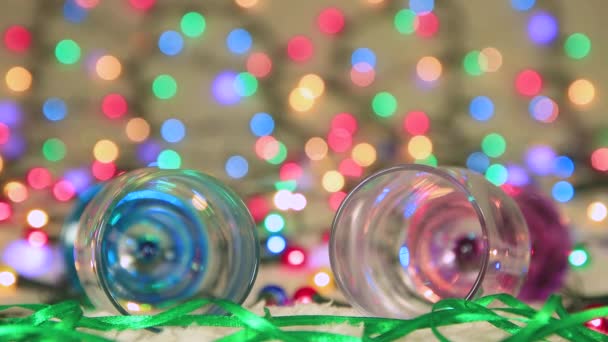 Ano Novo screensaver dois copos mentira contra o fundo das luzes de Natal — Vídeo de Stock