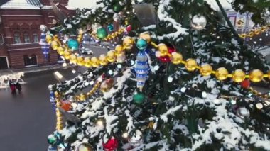 Bir Noel ağacının yeşil dallarında oyuncaklar ve yanan çelenkler.