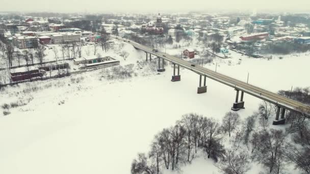 Bellissimo paesaggio invernale innevato, vista aerea, ponte stradale e fiume ghiacciato. — Video Stock