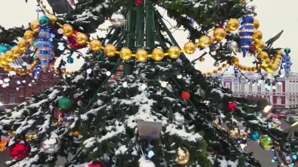 Glinsterende lichten op de groene takken van een straat kerstboom — Stockvideo