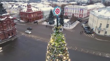 Güzel bir Noel ağacı Parlayan çelenkleri ile bir şehir caddesinde.