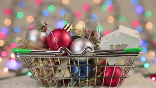 Palline di Natale spruzzata in un cestino sullo sfondo di luci di Natale. — Video Stock