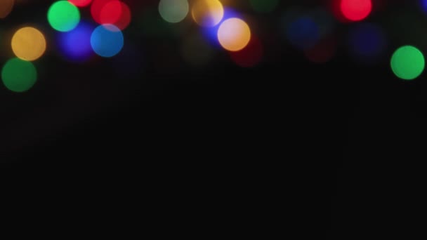 Above there are colored lights on a black background, copy space. — Stock Video