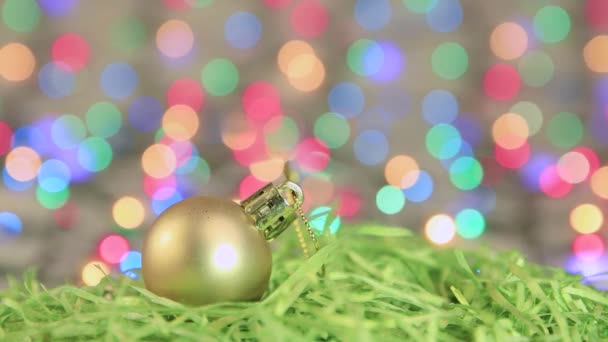 Weihnachten spritzt goldene Kugel auf dem Hintergrund der Silvesterbeleuchtung. Kopierraum. — Stockvideo