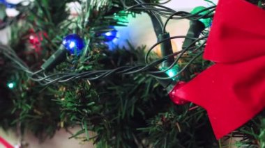 Yeşil bir dalda çok renkli Noel ışıkları çelenkleri
