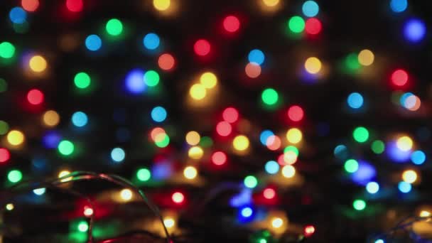 Όμορφα φωτισμένα πολύχρωμα χριστουγεννιάτικα φώτα σε μαύρο φόντο, αντιγραφή χώρου. — Αρχείο Βίντεο