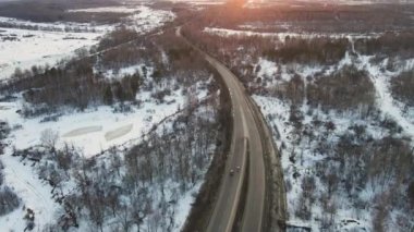 Gün batımında bir yolu olan fantastik kış manzarası, hava manzarası.