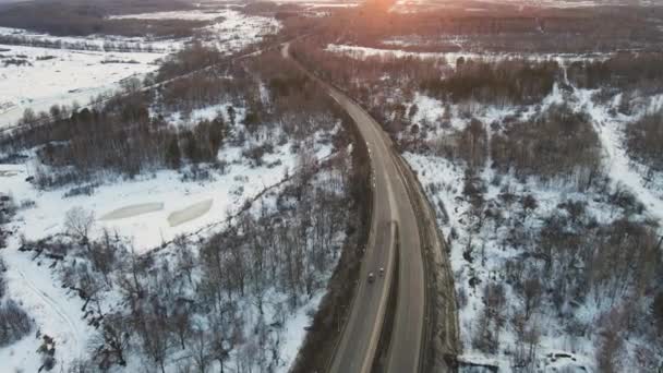 Paysage hivernal fantastique avec une route au coucher du soleil, vue aérienne. — Video
