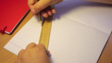 Bir lise öğrencisinin yakın çekim elleri cetvel boyunca geometrik bir figür oluşturur