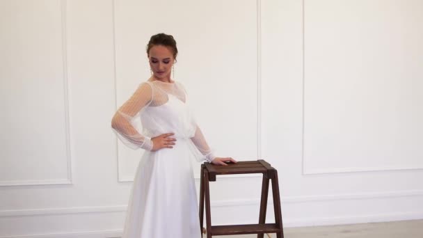 Az ideális modell menyasszony fehér ruhában pózol a fotósnak. — Stock videók