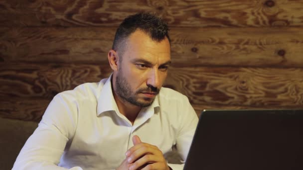Seorang pengusaha yang puas melihat dengan penuh perhatian pada layar, mempertimbangkan informasi — Stok Video