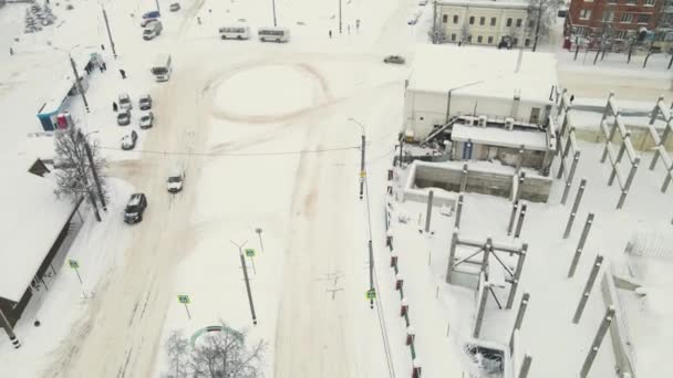 Pocos coches en la carretera circular de la ciudad cubiertos de nieve espesa después de una ventisca. — Vídeos de Stock